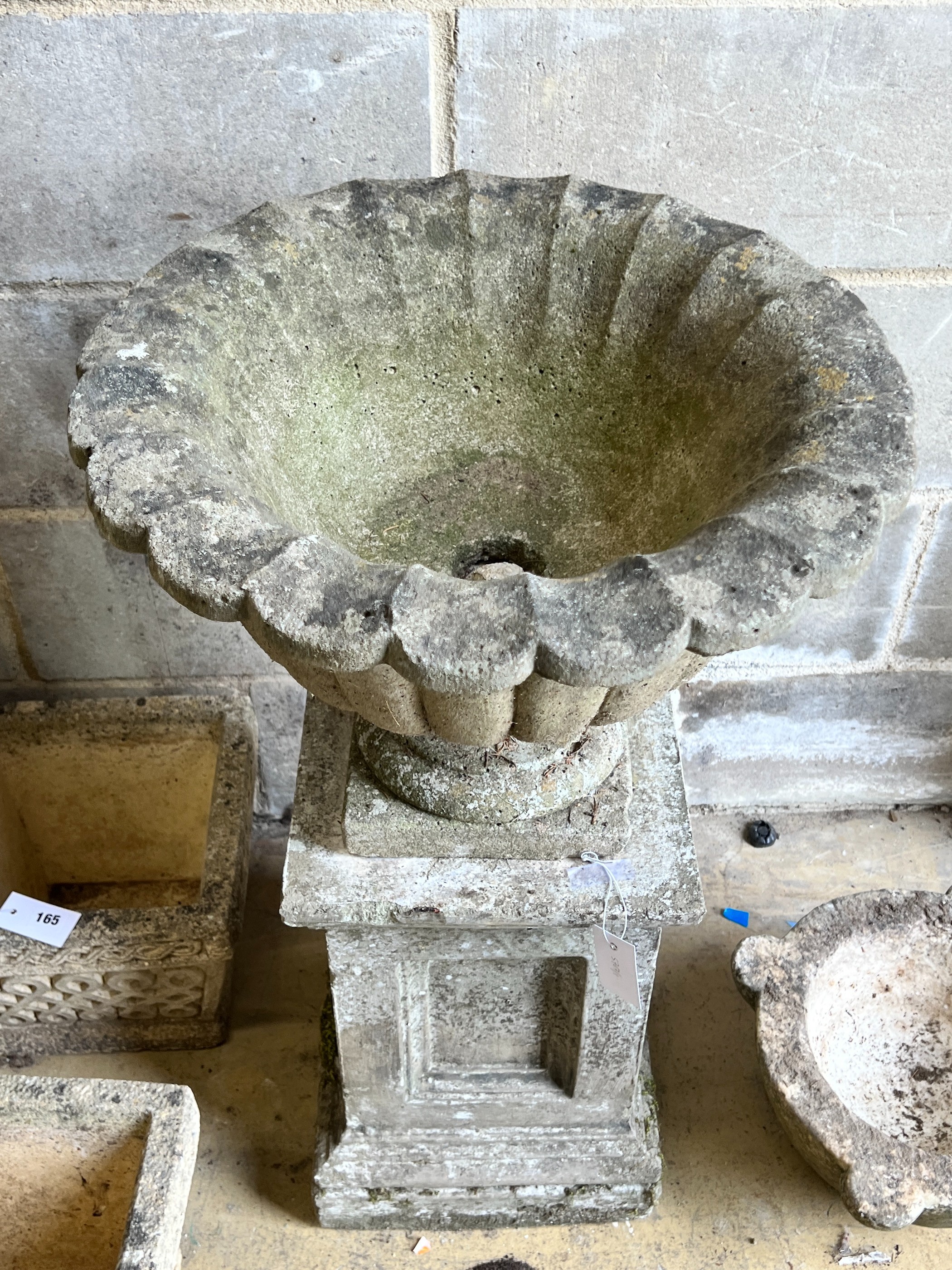 A reconstituted stone campana garden urn on square plinth, diameter 49cm, height 82cm